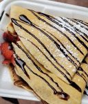 Crepa rellena de queso con topping de syrup de chocolate y nueces